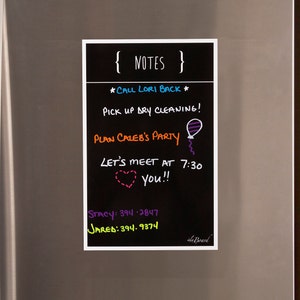 May include: A black chalkboard with white trim, labeled "NOTES" in white text. The board has a list of tasks written in colorful chalk, including "Call Lori Back", "Pick up dry cleaning", "Plan Caleb's Party", "Let's meet at 7:30", and "You!!".  Phone numbers for Stacy and Jared are also listed.