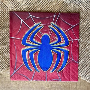 Puede incluir: Servilleta de papel roja y azul con una telara&ntilde;a amarilla y una ara&ntilde;a azul en el centro.