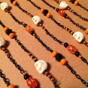 Skull Halloween Shower Curtain Decoration for Bathroom.  Black and orange with white howlite skulls.