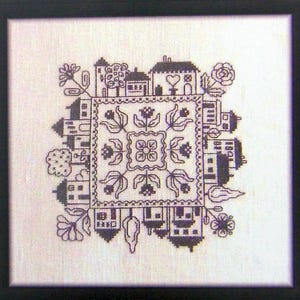 Può includere: Motivo a punto croce in bianco e nero di una piccola città con case, alberi e fiori. Il disegno è centrato su un quadrato con un motivo floreale.