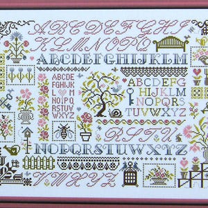 Puede incluir: Un sampler de punto de cruz con una variedad de motivos florales, incluyendo rosas, tulipes y margaritas. El sampler también incluye un pájaro, un caracol, una abeja, una llave, una regadera y una jaula para pájaros. El alfabeto se muestra en una variedad de fuentes y estilos, con cada letra rodeada de elementos decorativos.