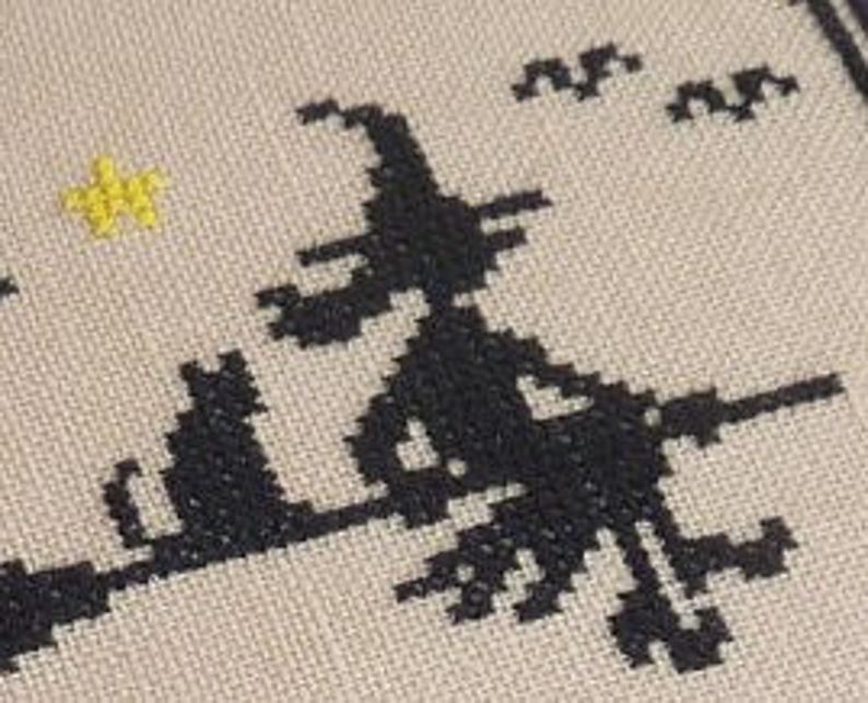 May include: Black and white cross-stitch pattern of a witch flying on a broomstick with a black cat sitting beside her. A yellow star is in the upper left corner of the image.