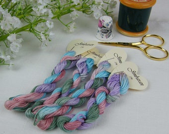 Fio de algodão tingido à mão em cores variadas: turquesa, malva, rosa e verde.