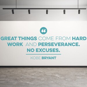 May include: A white wall with a motivational quote in blue text: "Great things come from hard work and perseverance. No excuses." The quote is attributed to Kobe Bryant.