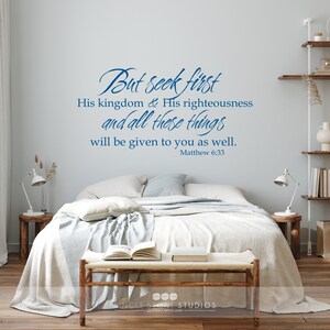 May include: A bedroom interior with a white bed, a wooden bench, and a wall decal with the Bible verse "But seek first His kingdom & His righteousness and all these things will be given to you as well. Matthew 6:33".