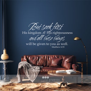 May include: A brown leather couch with a throw blanket in a living room setting. The wall behind the couch has a white vinyl decal with the text "But seek first His kingdom & His righteousness and all these things will be given to you as well. Matthew 6:33".