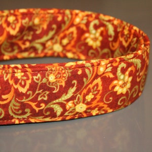May include: A red, orange, and green patterned dog collar with a black buckle.