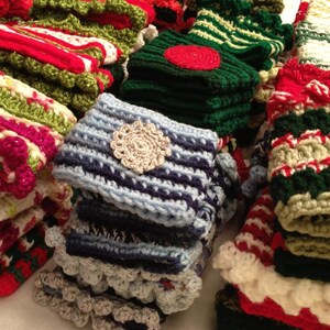 May include: A collection of colorful crocheted hats and scarves in various patterns and colors, including red, green, blue, white, and cream.