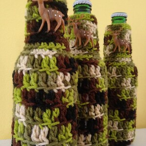 May include: Three glass bottles covered in crocheted camouflage fabric with small deer figurines attached to each bottle.