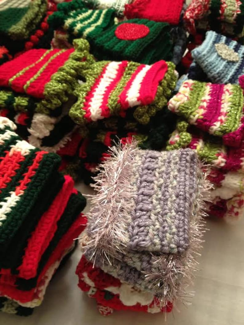 May include: A collection of colorful crocheted items, including hats, scarves, and other accessories. The items are made in a variety of colors, including red, green, white, and purple. Some of the items have a fluffy texture, while others are more smooth.