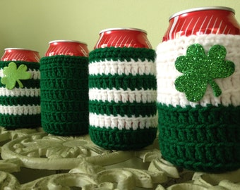 May include: Four green and white striped crocheted can cozies with shamrock embellishments. The cozies are made to fit standard size beverage cans.