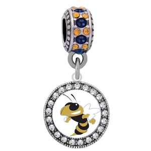 May include: Silver charm with a clear crystal encrusted circle featuring a cartoon yellow and black bee mascot. The charm has a silver bead with blue and yellow crystals.
