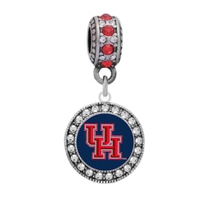 May include: A silver charm with a blue and red University of Houston logo surrounded by clear rhinestones. The charm has a silver bead with red rhinestones.