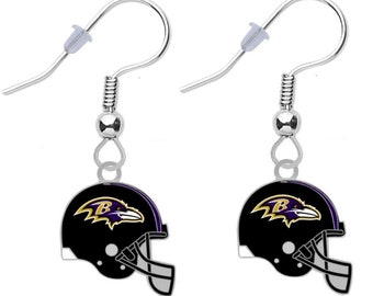 May include: A pair of silver dangle earrings featuring a black and purple football helmet with a raven logo. The helmet has a white 'B' on the side.