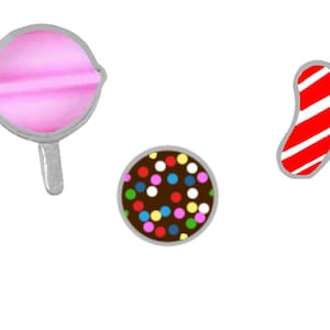 Puede incluir: Una colección de caramelos de dibujos animados sobre un fondo blanco. La imagen incluye una piruleta rosa, un caramelo de chocolate con chispas de colores y un bastón de caramelo a rayas rojas y blancas.