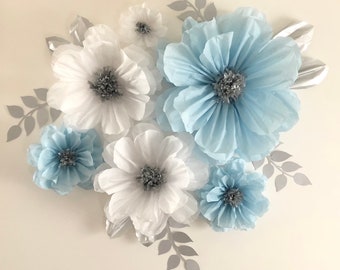 May include: A set of paper flowers in shades of blue and white with silver centers. The flowers are arranged in a cluster and are perfect for a wedding or party decoration.