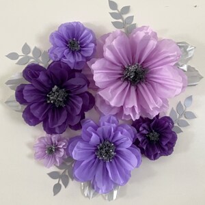 Pode incluir: Um conjunto de seis flores de papel em tons de roxo e lavanda. As flores est&atilde;o dispostas em um cacho e t&ecirc;m uma apar&ecirc;ncia texturizada e em camadas. As flores s&atilde;o perfeitas para adicionar um toque de eleg&acirc;ncia a qualquer c&ocirc;modo.