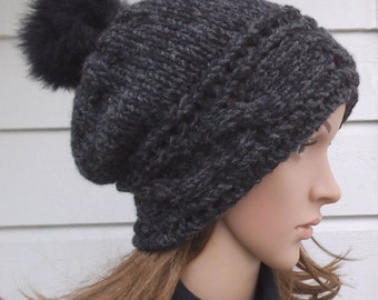 Sombrero de lana gris oscuro con pom-pom en la parte superior. Sombrero de punto a mano. Sombrero de mujer de invierno. Sombrero de lana.