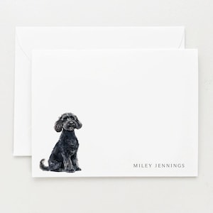 May include: A white card with a black dog sitting on it. The dog is looking at the camera. The text "MILEY JENNINGS" is printed at the bottom of the card.
