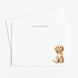 May include: A set of stationery with a watercolor illustration of a puppy. The stationery includes a white envelope and a white card with the name "Rosie Denner" printed at the top. The puppy is light brown with floppy ears.