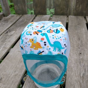 Ready to Ship Teal Dinosaurs with White Mesh Hearing Aid Cap for those with hearing aids/ cochlear implants