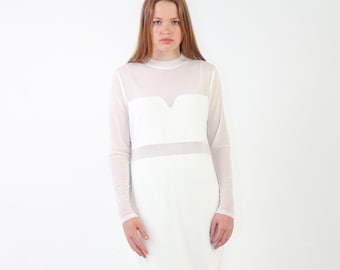 Könnte beinhalten: Ein weißes Langarmkleid mit einem transparenten Netzstoff-Overlay am oberen Brustbereich und an den Ärmeln, einem hohen Ausschnitt sowie einem blickdichten weißen Einsatz über das Oberteil und den Rock. Das Kleid hat eine gerade Passform.