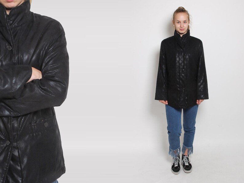 May include: A black quilted jacket with a high collar and a button closure. The jacket has a slightly oversized fit and is made of a soft, comfortable material.