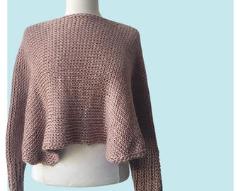 May include: A mauve knitted sweater with long sleeves and a cropped hem.