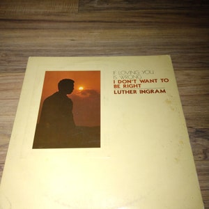 May include: A yellow vinyl record with a silhouette of a person in front of a sunset. The text on the record reads "If loving you is wrong, I don't want to be right. Luther Ingram."