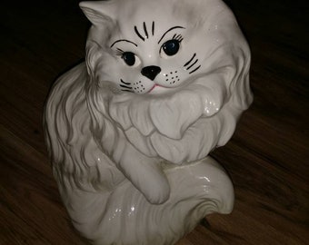 Vintage ceramic Persian cat statue with blue eyes and raised paw