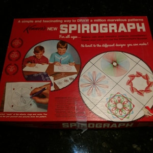 May include: A red box with the words "Kenner's NEW SPIROGRAPH" on the front. The box shows children drawing colorful geometric patterns with a Spirograph drawing tool. The text on the box says "A simple and fascinating way to DRAW a million marvelous patterns".