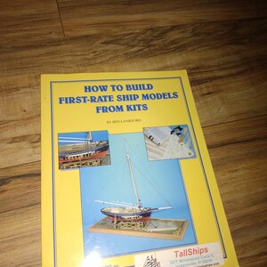 May include: A yellow book titled "How to Build First-Rate Ship Models From Kits" by Ben Lankford. The book cover features a model ship on a wooden stand. The book is published by TallShips, a company that sells ship models and kits.