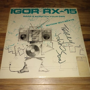 May include: A white record album cover with a black and white illustration of a boombox with legs and sneakers. The album cover has the text "IGOR RX-15", "RAPP & SCRATCH YOUR OWN", "NUTHIN' BUT BEATS", "Terry", and "Jokh Sou" on it.