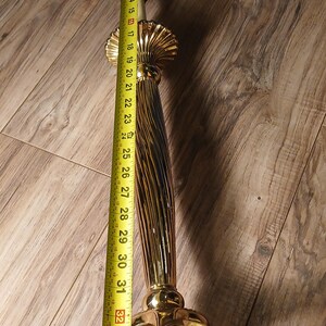 May include: A gold-colored lamp base with a fluted column design, measuring approximately 37 inches in height. The base has a decorative, ornate design and is shown with a measuring tape.