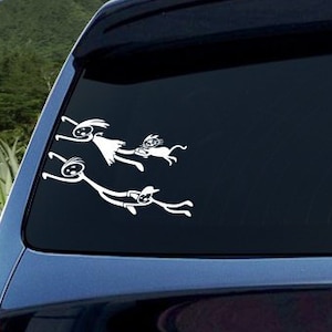 May include: A white car with a rear window sticker depicting a family of stick figures. The figures are holding hands and appear to be jumping or flying.