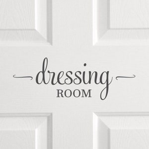 May include: White door with a black vinyl decal that reads "dressing room" in a cursive font.