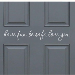 May include: A grey door with a white vinyl decal that reads "have fun. be safe. love you."