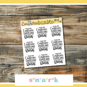 May include: A sheet of stickers with the text "I run on caffeine, chaos, and cuss words" in a handwritten font. The stickers are white with black text and are arranged on a wooden background. The brand name "Southern Bumble" is at the top.