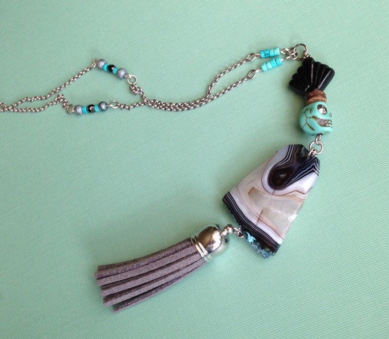 A tiny skull and tassel necklace with a faceted agate stone image 0
