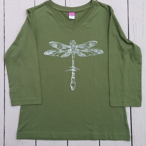 May include: A green long-sleeved shirt with a white dragonfly graphic on the front.