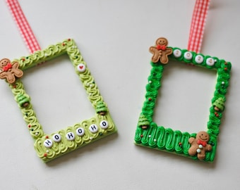May include: Two rectangular picture frames decorated with faux green frosting, gingerbread figures, and small trees. One frame features the text HOHOHO and a heart, while the other displays 2024. Both include red and white checkered ribbon hangers.