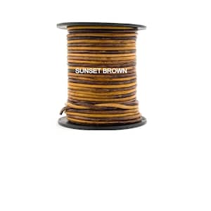 Pu&ograve; includere: Un rotolo di cordoncino in pelle marrone, etichettato "SUNSET BROWN".