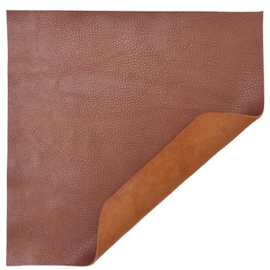 Può includere: Un pezzo di pelle marrone con una superficie strutturata. La pelle è piegata per mostrare il retro in camoscio marrone.