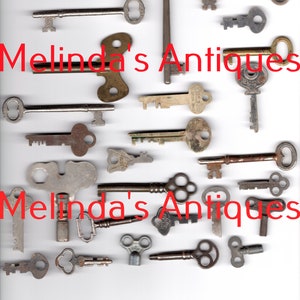 May include: A collection of antique keys in various styles and sizes. The keys are made of metal and have a variety of finishes, including brass, silver, and copper. The keys are arranged on a white background. The text "Melinda's Antiques" appears twice in the image.