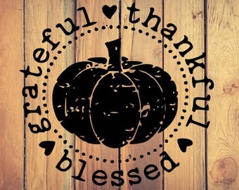May include: A black and white graphic design with a pumpkin and the words "grateful thankful blessed" in a circle around it.