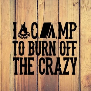 May include: Black and white text on a wood background that reads "I camp to burn off the crazy". The text includes a campfire and a tent icon.