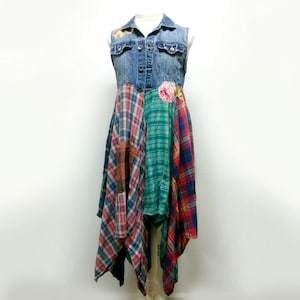 Puede incluir: Un vestido de chaleco vaquero con una falda de patchwork hecha de tela a cuadros en rojo, verde y azul. El vestido tiene un adorno floral en la parte delantera.