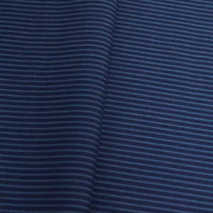 May include: A close-up of a blue and white striped fabric. The fabric has a subtle texture and a slightly faded look.