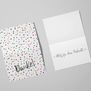 May include: A white card with a colorful confetti pattern and the word "Danke!" printed in black. The inside of the card is blank with the text "Platz f&uuml;r deine Nachricht" printed in black.