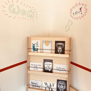 May include: A wooden postcard display rack with various cards featuring animal illustrations and humorous text. The cards include a llama, lion, monkey, and lion wearing sunglasses. The word "WOW" is written on the wall.